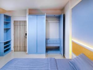 um quarto com uma cama azul e um armário em Chateau Hotel & Apartments em Pathum Thani