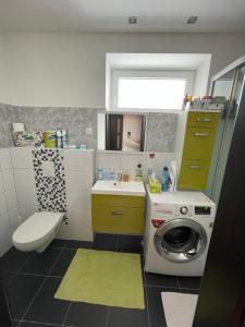 a bathroom with a washing machine and a sink at Plně vybavený krásný apartmán 1kk s balkonem, výhledem in Jablonec nad Nisou