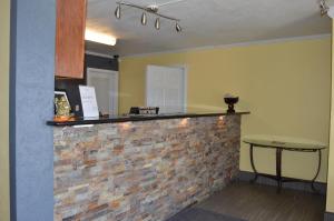 eine Küche mit einer Backsteintheke und einem Tisch in der Unterkunft Bedford Inn in Elk City