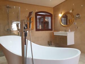 a bathroom with a large tub and a sink at Mahdia - Baghdadi - Laourient Apartments, restaurant, café in Mahdia