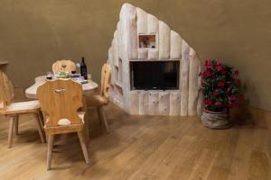 a living room with a table and chairs and a tv at Magical Hobbit's House - Happy Rentals in Ljutomer