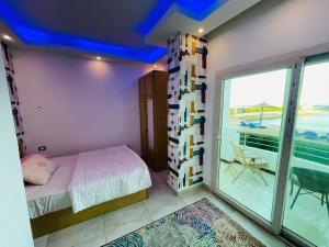 a bedroom with a bed and a balcony at Furnished Chalets for Rent in Cecilia Resort in Hurghada