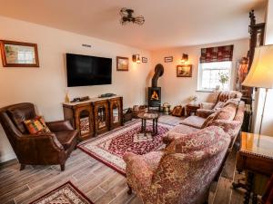 a living room with couches and a flat screen tv at Station Masters Cottage in Kidderminster