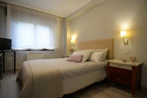 奧萊羅斯的住宿－A Coruña - Playa Santa Cristina, Perillo-Oleiros，一间卧室设有一张大床和一个窗户。