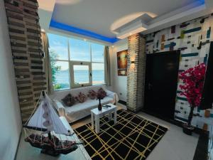een woonkamer met een bank en een groot raam bij Furnished Chalets for Rent in Cecilia Resort in Hurghada