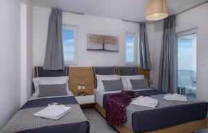 een slaapkamer met 2 bedden en handdoeken bij Deluxe City Hotel in Chania