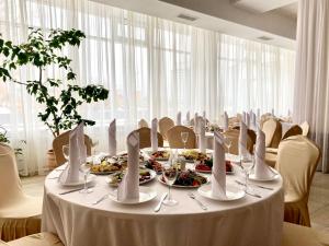 ein Esszimmer mit einem Tisch und Teller mit Lebensmitteln in der Unterkunft AMAKS City Hotel in Krasnojarsk