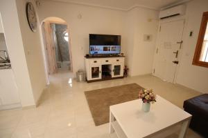 un soggiorno con TV e tavolo di Ferienhaus mit Privaten Pool ad Alicante
