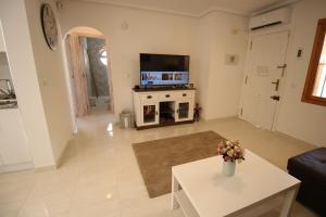 Una sala de estar con un televisor y una mesa. en Ferienhaus mit Privaten Pool, en Alicante