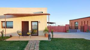 a house with two chairs sitting outside of it at Trafalgar Polo Club in El Palmar