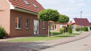 a brick house with a tree next to a street at Ferienwohnung Safari in Liepgarten