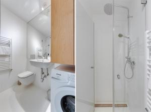 ein weißes Bad mit einer Waschmaschine und einer Dusche in der Unterkunft Elegant Studio Apartment with Panoramic View in Nova Gorica