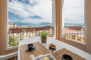 デセンツァーノ・デル・ガルダにあるGardappartamenti Cavour Lake Viewのテーブル付きの客室で、バルコニーから景色を望めます。