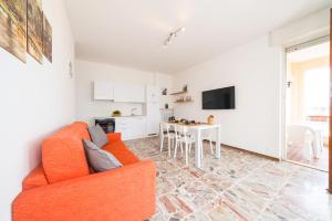 a living room with an orange couch and a table at Gardappartamenti Cavour Lake View in Desenzano del Garda
