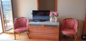 sala de estar con 2 sillas rojas y TV en Apartman JASNA, en Opatija