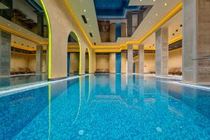 ein großer Pool in einem Gebäude mit blauem Wasser in der Unterkunft Zlatibor apartman 34 Wellness&Spa in Zlatibor