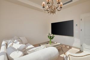 a living room with a white couch and a chandelier at Villa Lovorno in Arbanasi