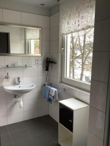 a white bathroom with a sink and a window at Budgethotel Stadtbett Wolfsburg in Wolfsburg +35 photos