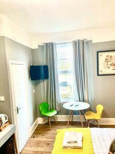 1 dormitorio con 1 cama, mesa y sillas en The Westbank, en Torquay