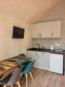 a kitchen with a table and chairs in a room at Przystań Narie in Kretowiny