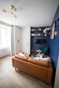 - un salon avec un canapé et un mur bleu dans l'établissement STERENN Joli T2 - 900m de la gare - Centre Dinan, à Dinan