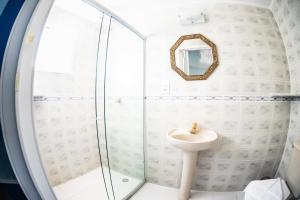 a bathroom with a sink and a shower at Pousada Gente Bonita Centro in Búzios