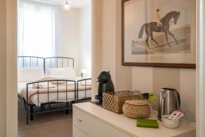 1 dormitorio con 1 cama y un cuadro de caballos en la pared en L'Angelica Holiday Home, en Desenzano del Garda