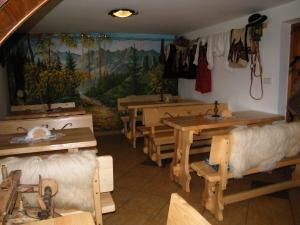 U Poraja في زومب: غرفة بطاولات وكراسي ودهان على الحائط