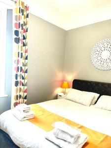 1 dormitorio con 1 cama grande con sábanas blancas en The Westbank, en Torquay