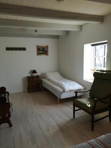a bedroom with a bed and a chair and a window at Bøgehus in Vejle