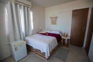 a bedroom with a bed and a small table at Casa Beira mar enseada dos golfinhos- Itamaracá in Jaguaribe +4 photos