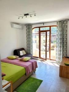a bedroom with a bed and a large window at Obzor Tatyana Apartaments Natura in Obzor
