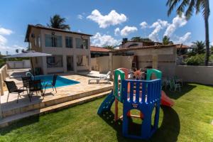 a house with a playground in the yard at Casa Beira mar enseada dos golfinhos- Itamaracá in Jaguaribe