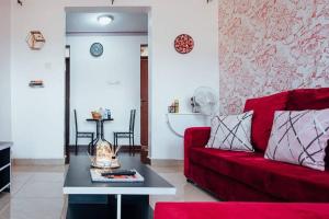 a living room with a red couch and a table at Sakura 2BR1B in Kampala +16 photos