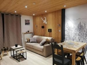 a living room with a couch and a table at Les Deux Alpes, Le Lauvitel, appartement cosy, pied des pistes, 2 adultes 2 enfants in Les Deux Alpes