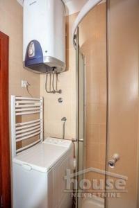 a small bathroom with a washing machine and a shower at Sofy Center Apartment (Free Parking) in Novi Sad
