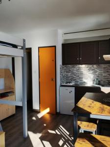 a kitchen with an orange door in a room at Un Isard au Pied des Pistes in Ax-les-Thermes