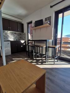 a living room with a table and some chairs at Un Isard au Pied des Pistes in Ax-les-Thermes