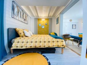1 dormitorio con 1 cama con colcha amarilla en L'ESCAPADE, en Laon