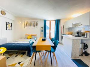 a bedroom with a bed and a table and a kitchen at L'ESCAPADE in Laon
