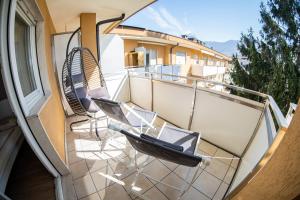 a balcony with two chairs and a window at Flow Apartments Wolkenstein in Merano