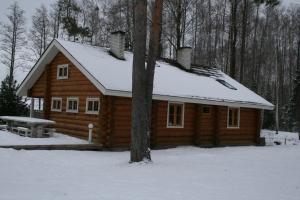 une cabane en rondins avec de la neige sur le toit dans l'établissement Trepimäe Holiday House, à Vehendi