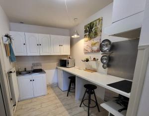 a small kitchen with white cabinets and a counter at pour vos séjours pro ou détentes in Issoire
