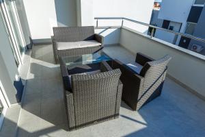balkon z 2 krzesłami i szklanym stołem w obiekcie Apartment Villa Lumada with Pool w Novalji