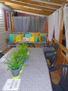 a table and chairs in a room with a couch at MOBILHOME 3CH LAVE LINGE - EXT COCOONING ES117 in Fréjus