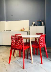 cocina con mesa y 2 sillas rojas en Residenza Avogadro, en Turín