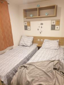 two beds in a small room with at MOBILHOME 3CH LAVE LINGE - EXT COCOONING ES117 in Fréjus