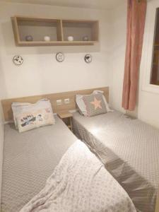 a small bedroom with two beds and a window at MOBILHOME 3CH LAVE LINGE - EXT COCOONING ES117 in Fréjus