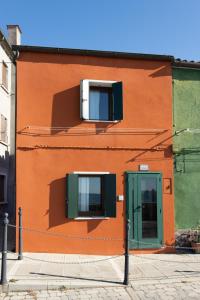 a orange building with two windows and a door at Dimora Rubino - Isola di Pellestrina Ve in Pellestrina