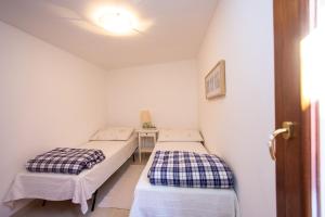 two beds in a small room with a window at Dimora Rubino - Isola di Pellestrina Ve in Pellestrina